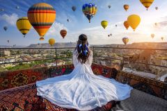 Beautiful-girl-sitting-on-the-hotel-and-looking-to-hot-air-balloons-in-Cappadocia-Turkey-scaled