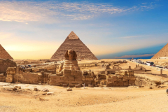 Egypt-Pyramids-and-Sphinx-panorama-behind-the-palm-with-a-camel-lying-by-Cairo-Giza-scaled